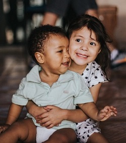 preschooler holding a toddler on lap